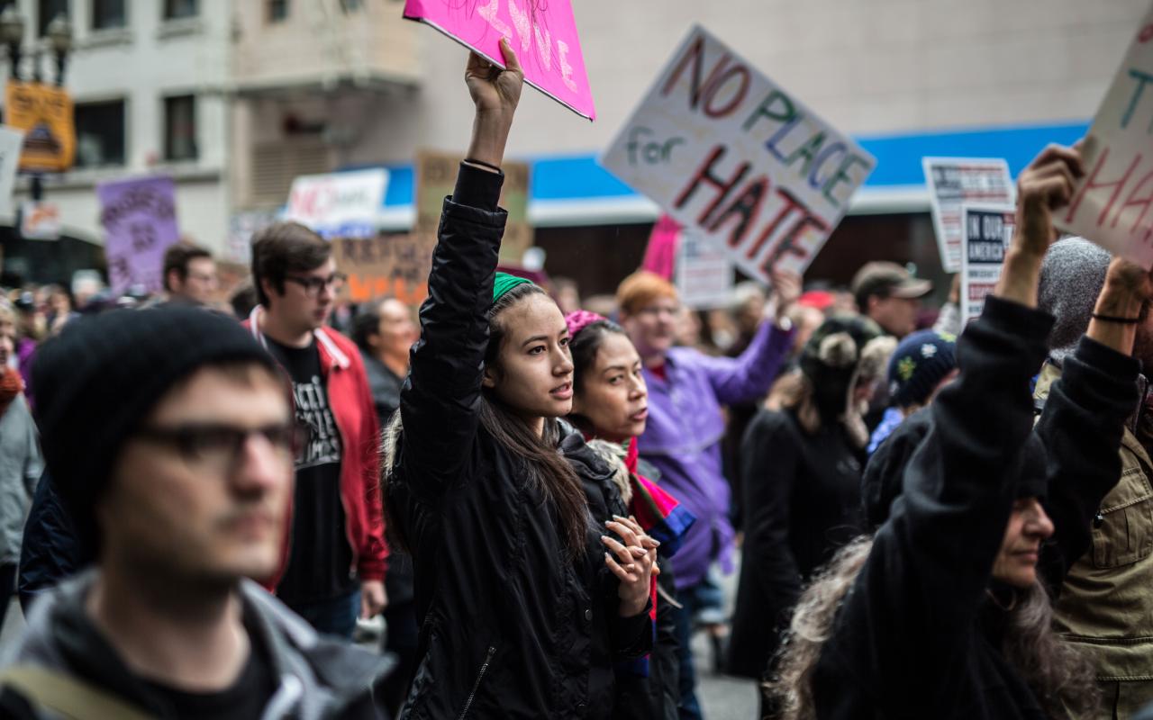 protesters hold signs at a demonstration in Portland
