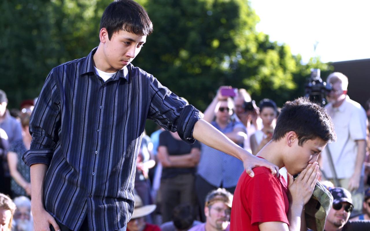 Hundreds gathered at a vigil at the Hollywood Transit Center on the evening after the Portland stabbings. Here one young man comforts another during a moment of silence.