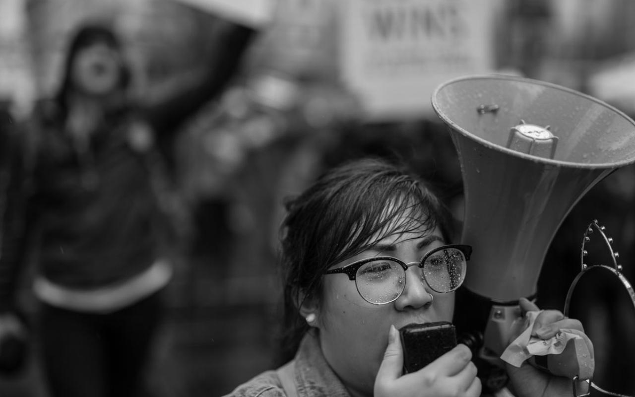 A demonstrator speaking into a bull horn during the “Strengthening Action for Justice.” convening. Photo credit: Jamie Francis
