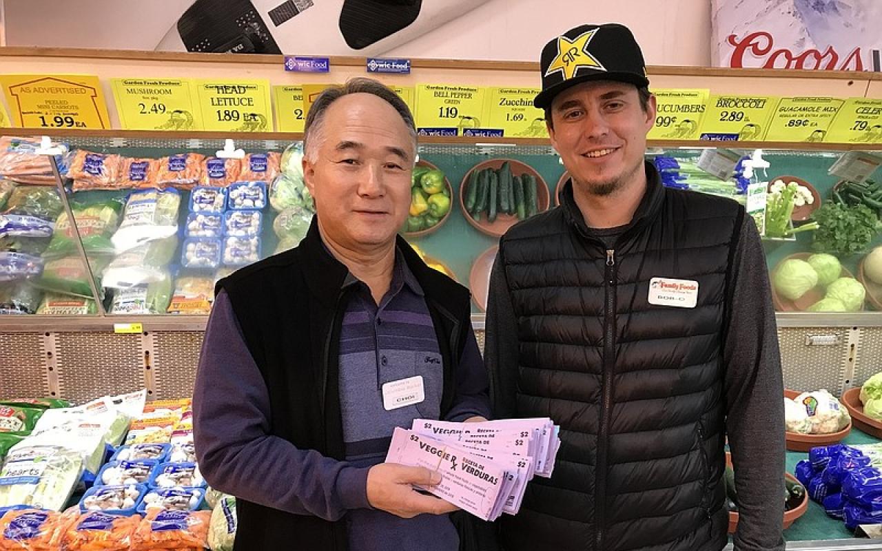 Albert Choi, owner, and Bobby Young, manager, of Columbia Market in Cascade Locks hold the Veggie Rx vouchers redeemed for fresh fruit and vegetables by local customers. 