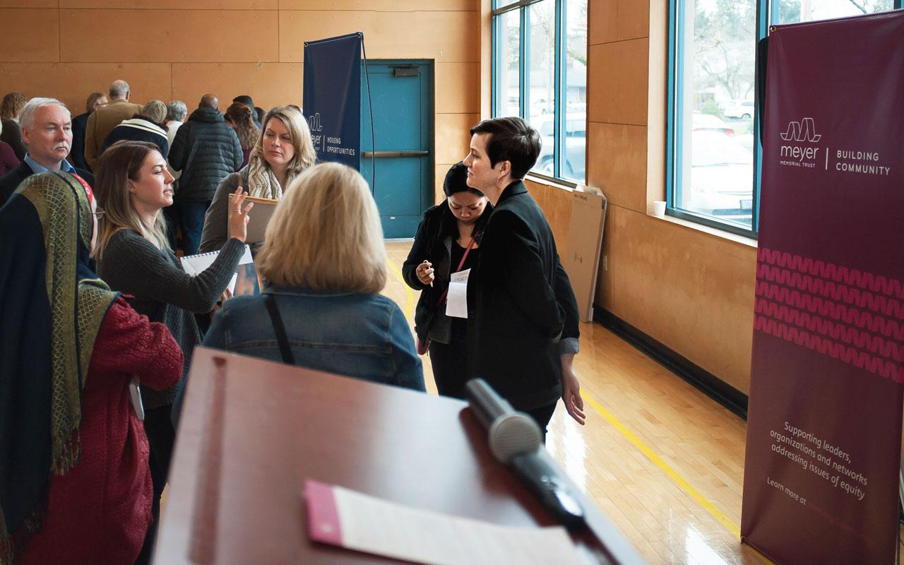 Building Community program associate Erin Dysart conversing with community members at Meyer's 2018 Annual Funding Opportunity information session at Immigrant and Refugee Organization (IRCO).