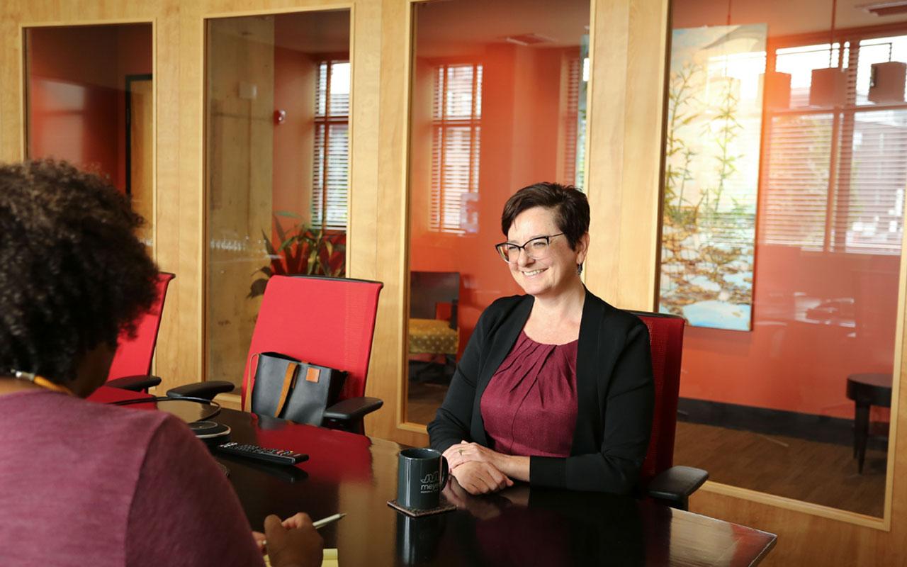 Photo caption: Meyer director of programs smiles during conversation with director of communications Kimberly A.C. Wilson.