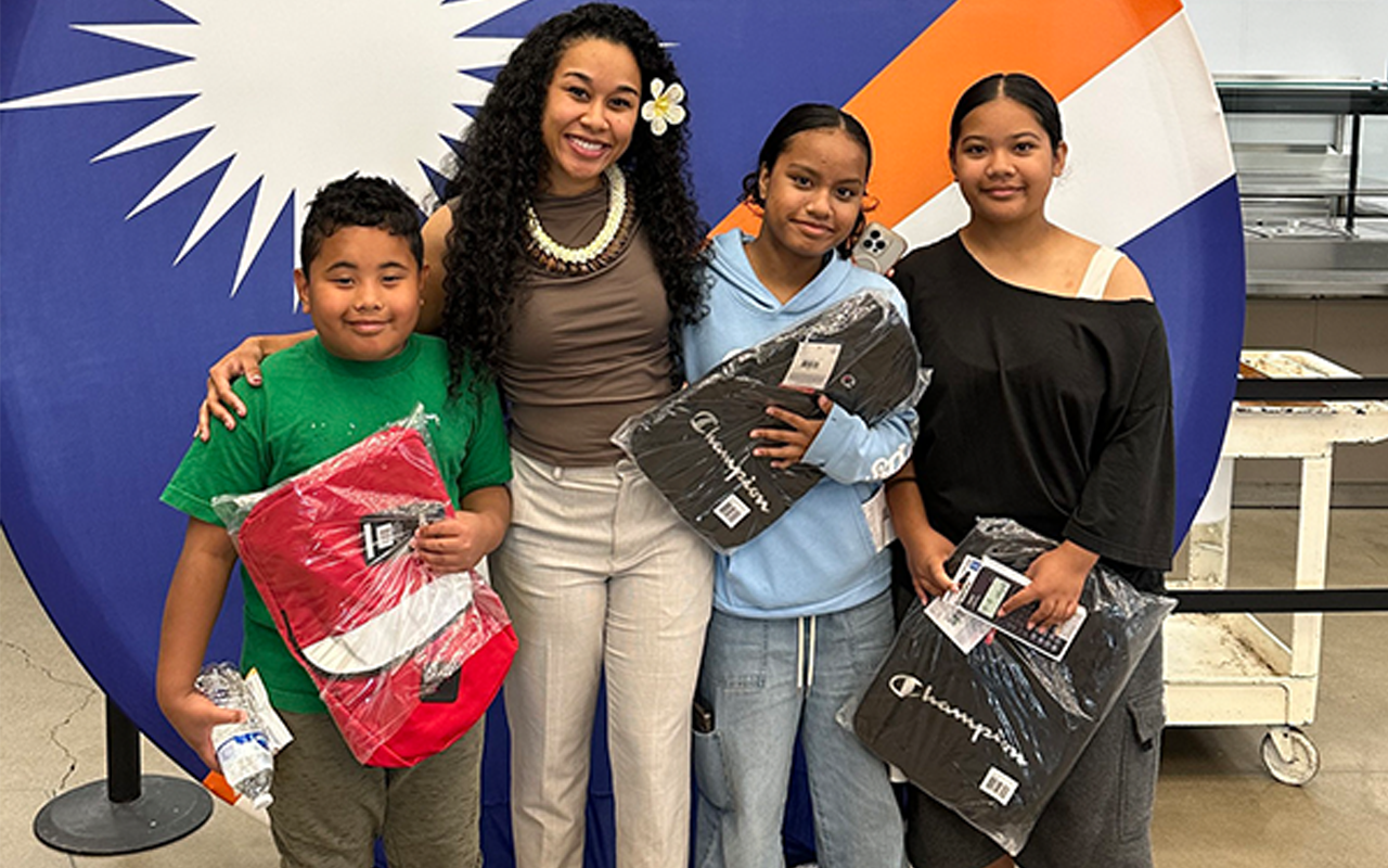 Billma Peters stands next to Marshallese youth