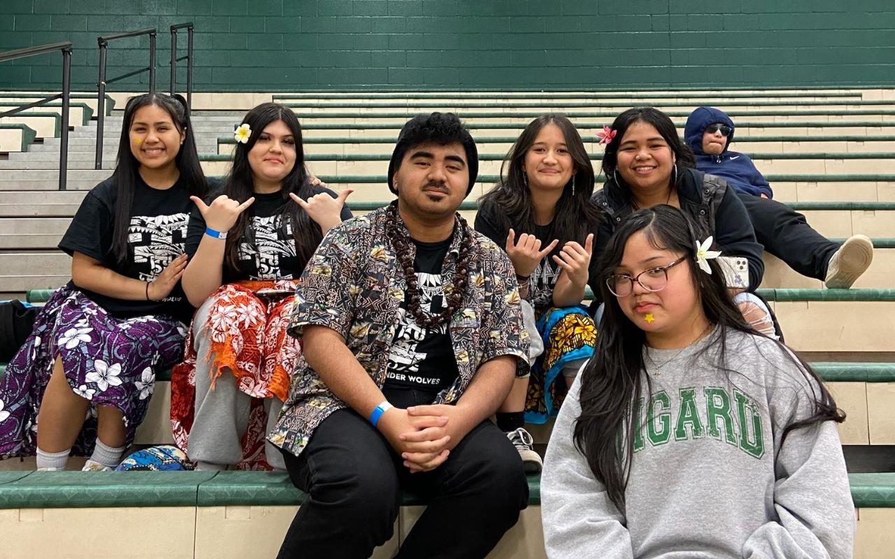 Pacific Islanders sit on bleachers at Tigard High School